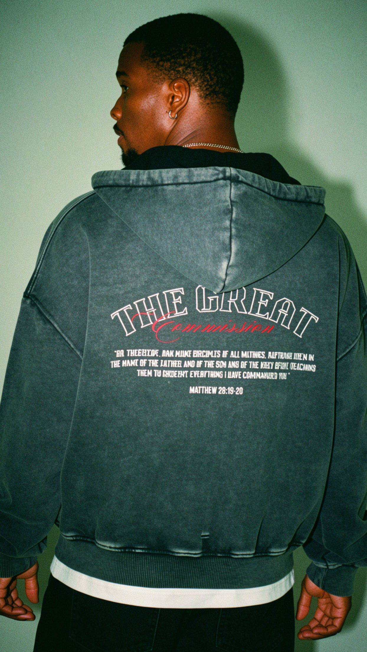 Young adult wearing oversized Christian hoodie outdoors