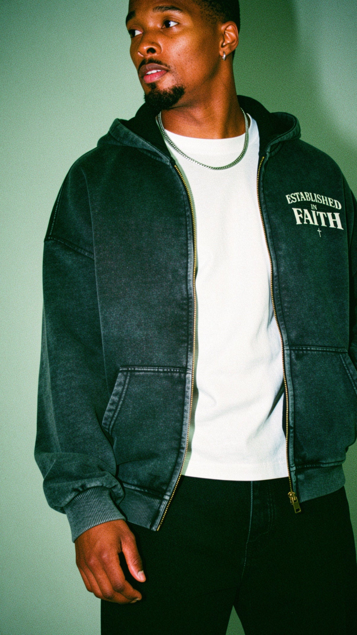 Young adult wearing oversized Christian hoodie outdoors